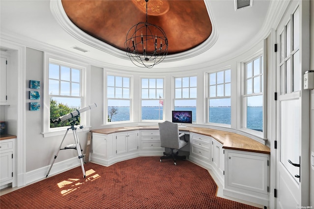 office space featuring a tray ceiling, carpet, and built in desk