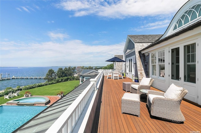 wooden terrace with a swimming pool with hot tub, a water view, and french doors