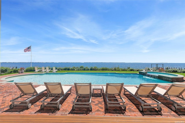 view of swimming pool with an in ground hot tub, pool water feature, and a water view