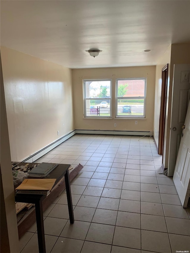 unfurnished room featuring light tile patterned floors and a baseboard radiator