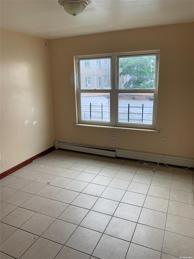 empty room with light tile patterned floors and baseboard heating