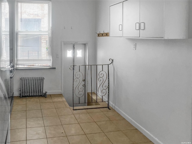 stairs featuring tile patterned flooring and radiator heating unit