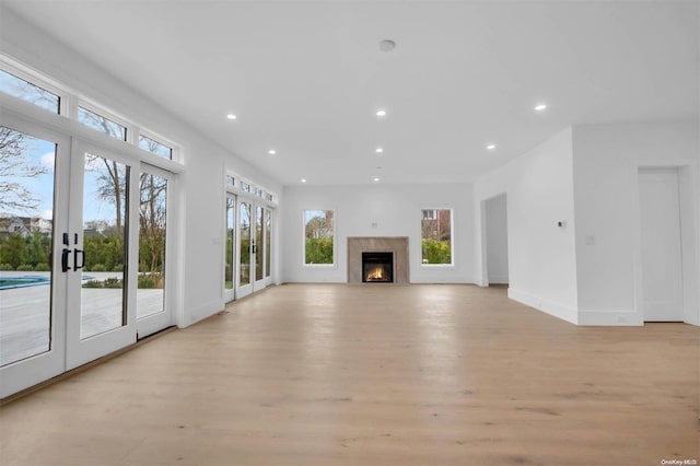 unfurnished living room featuring light hardwood / wood-style floors and french doors