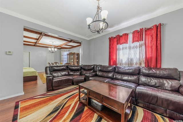 living room featuring hardwood / wood-style floors, an inviting chandelier, coffered ceiling, and crown molding