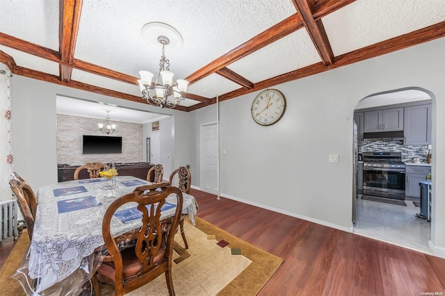 dining room with dark hardwood / wood-style floors, a textured ceiling, and an inviting chandelier