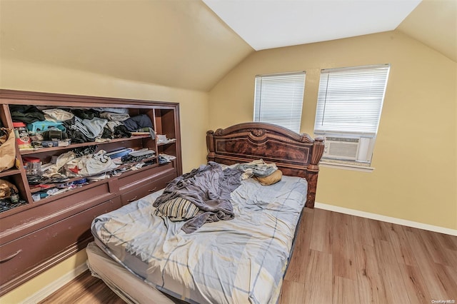 bedroom with light wood-type flooring, cooling unit, and lofted ceiling