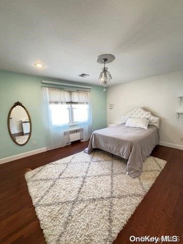 bedroom with radiator and dark wood-type flooring