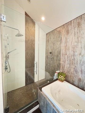 bathroom with tile walls, plus walk in shower, and lofted ceiling