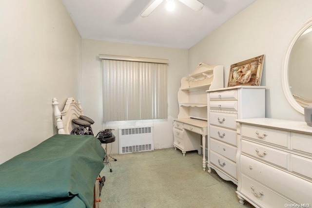 carpeted bedroom featuring ceiling fan and radiator