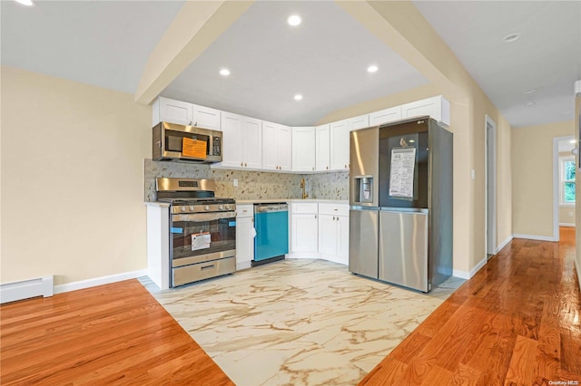 kitchen featuring backsplash, light wood-type flooring, a baseboard radiator, white cabinetry, and stainless steel appliances