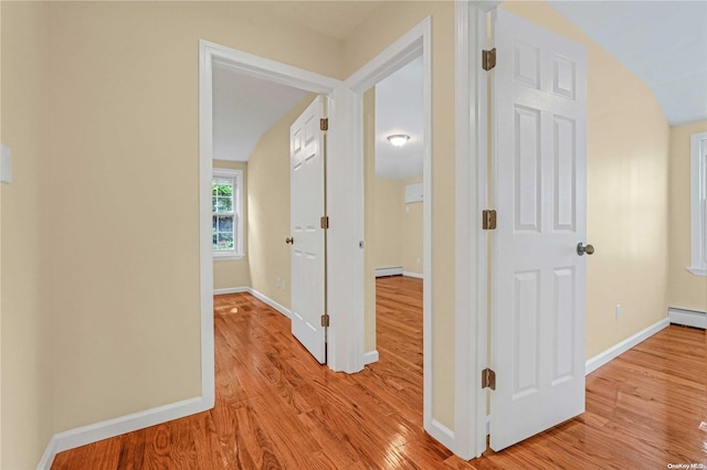 corridor with baseboard heating and light hardwood / wood-style flooring