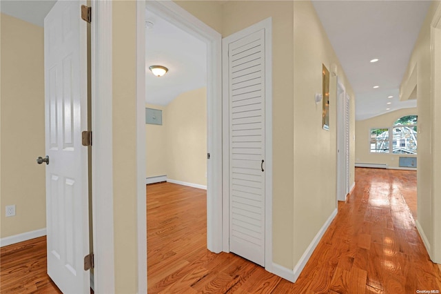 hallway with light hardwood / wood-style floors and a baseboard heating unit