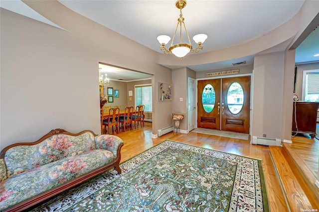 foyer entrance with light hardwood / wood-style floors, a wealth of natural light, and a chandelier