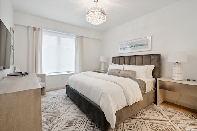 bedroom with light hardwood / wood-style flooring and a chandelier