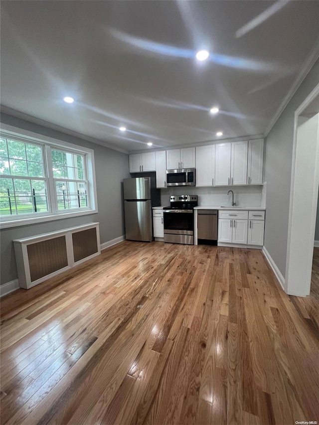 kitchen featuring light wood-type flooring, stainless steel appliances, white cabinetry, and sink