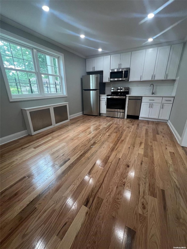 kitchen featuring light hardwood / wood-style floors, sink, white cabinetry, and stainless steel appliances