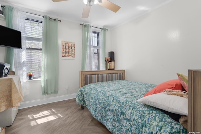 bedroom featuring multiple windows, ceiling fan, and parquet floors