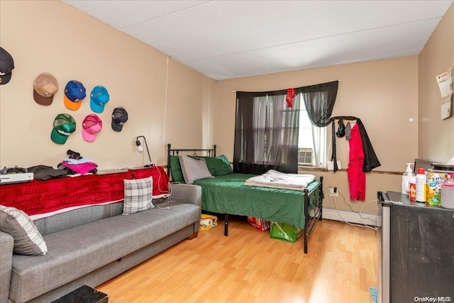 bedroom featuring hardwood / wood-style flooring and baseboard heating