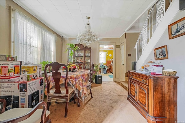 carpeted dining room with a healthy amount of sunlight and an inviting chandelier