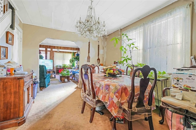 dining room featuring a healthy amount of sunlight, carpet floors, and an inviting chandelier