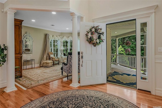 22 Saints Orchard Rd, Port Jefferson, NY 11777 - entryway with ornate columns, light wood finished floors, and ornamental molding