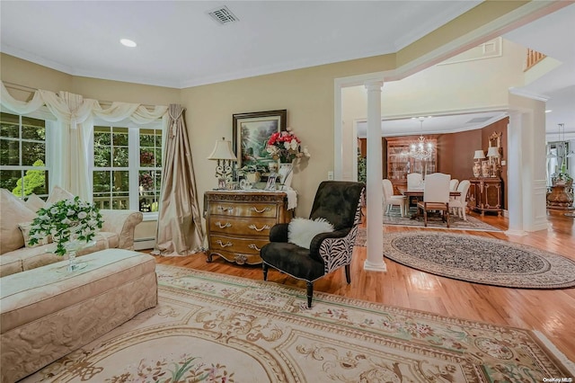 22 Saints Orchard Rd, Port Jefferson, NY 11777 - living area with decorative columns, wood finished floors, ornamental molding, a chandelier, and a baseboard heating unit