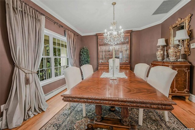 22 Saints Orchard Rd, Port Jefferson, NY 11777 - dining space with baseboard heating, a chandelier, wood finished floors, ornamental molding, and baseboards