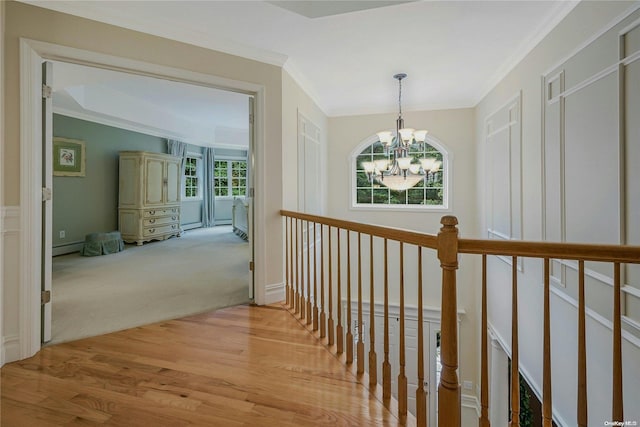 22 Saints Orchard Rd, Port Jefferson, NY 11777 - hallway with a chandelier, wood finished floors, an upstairs landing, crown molding, and carpet
