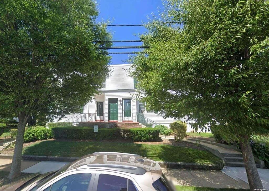 494 S Ocean Ave Unit 1H, Freeport, NY 11520 - view of front facade featuring a front yard
