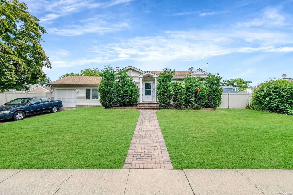 263 N Park Dr, Massapequa, NY 11758 - view of front facade featuring a garage and a front yard