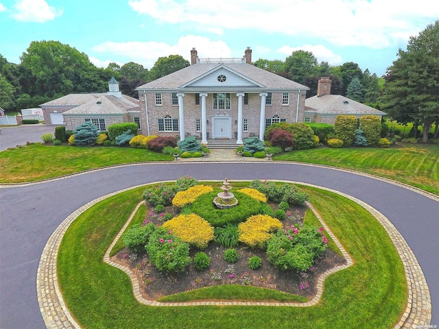 neoclassical / greek revival house featuring covered porch and a front lawn