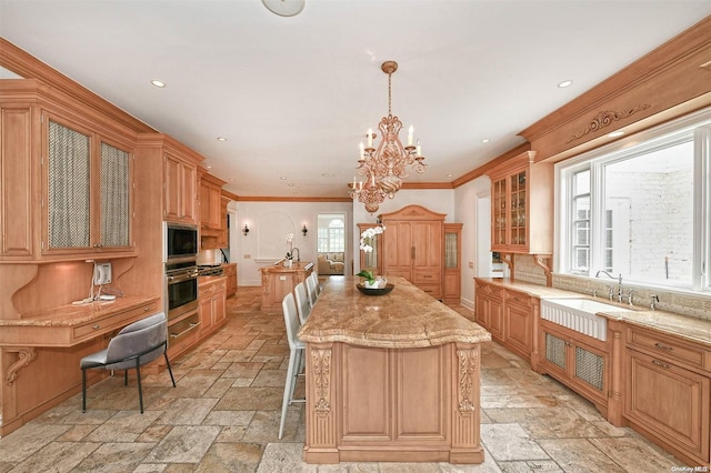 kitchen featuring a center island, stainless steel appliances, a chandelier, decorative light fixtures, and ornamental molding