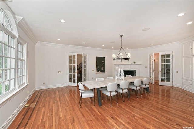 dining room with crown molding, hardwood / wood-style floors, and a chandelier