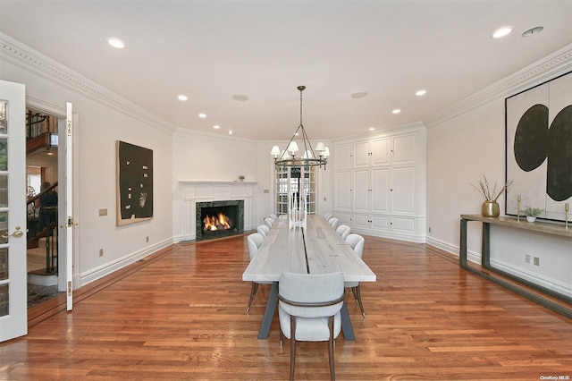 dining room featuring crown molding, a high end fireplace, and hardwood / wood-style flooring