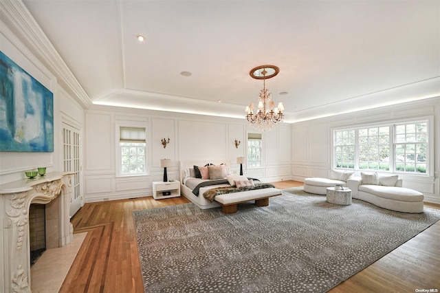 living room featuring hardwood / wood-style floors, a healthy amount of sunlight, a raised ceiling, and a chandelier