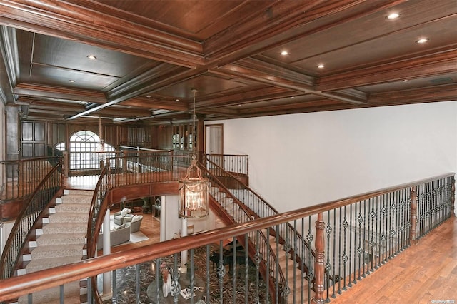 corridor with beamed ceiling, hardwood / wood-style floors, crown molding, and coffered ceiling