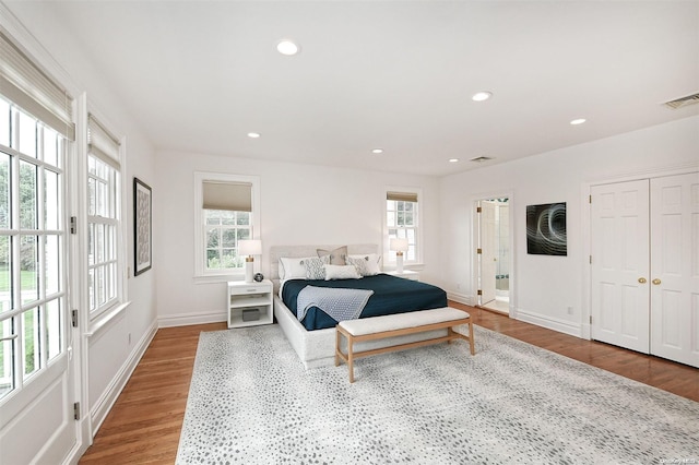 bedroom with hardwood / wood-style floors and multiple windows