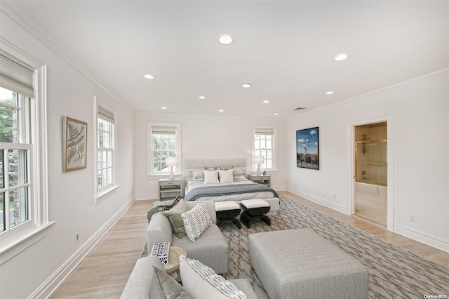 bedroom with light wood-type flooring, multiple windows, and ensuite bath