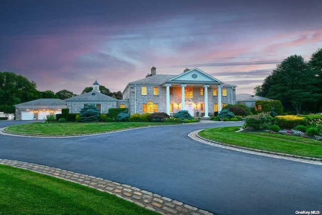 greek revival inspired property featuring a lawn