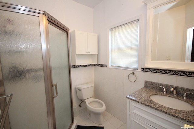 bathroom featuring vanity, tile patterned flooring, toilet, tile walls, and walk in shower