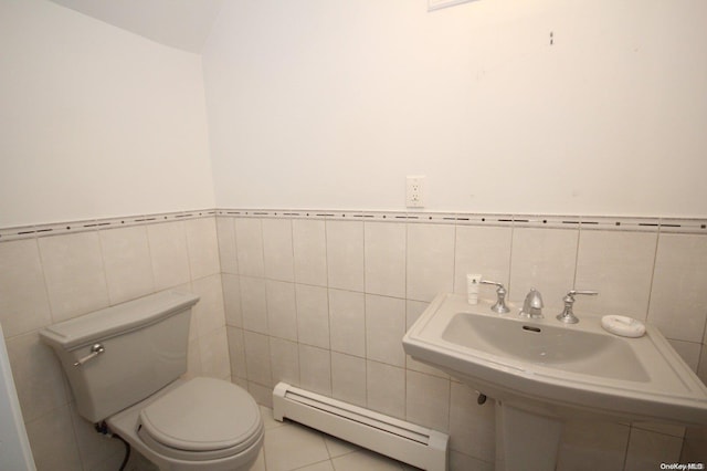 bathroom featuring toilet, baseboard heating, and tile walls