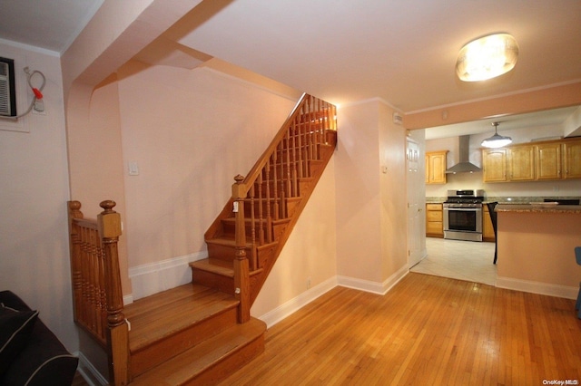 stairway with crown molding and wood-type flooring