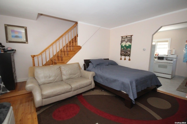 bedroom with ornamental molding and hardwood / wood-style flooring