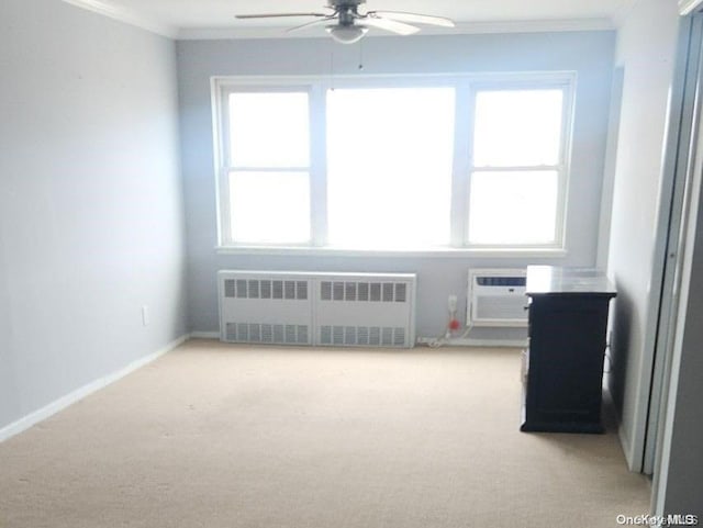 carpeted empty room featuring plenty of natural light, radiator, crown molding, and ceiling fan