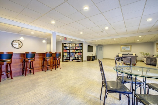 dining area featuring a drop ceiling and light wood-type flooring