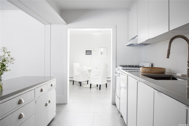 kitchen featuring white cabinets, white range oven, light tile patterned floors, and sink