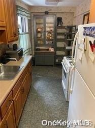 kitchen featuring white appliances and sink