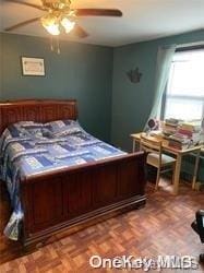 bedroom featuring ceiling fan and parquet flooring