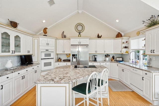 kitchen with decorative backsplash, sink, a kitchen island, and white appliances