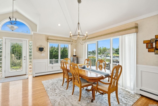 14C Penny Ln, Hampton Bays, NY 11946 - dining area featuring a chandelier, a baseboard radiator, a wainscoted wall, light wood finished floors, and vaulted ceiling